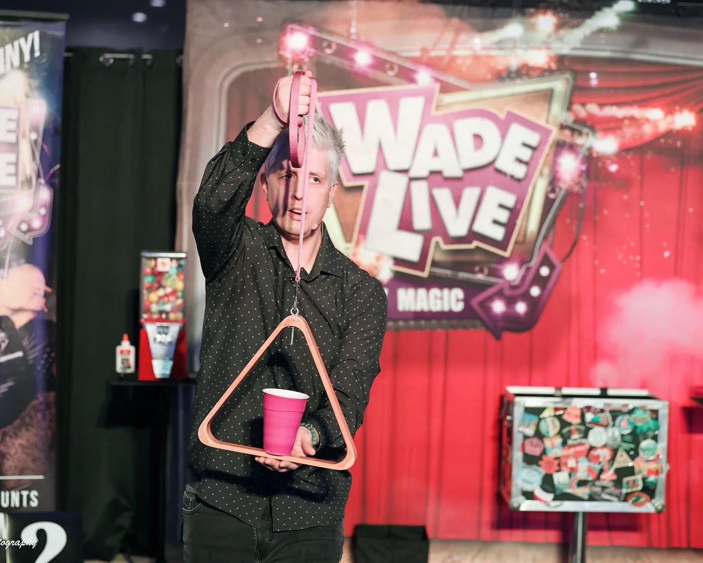 Wade Live performing a cup and frame routine on stage